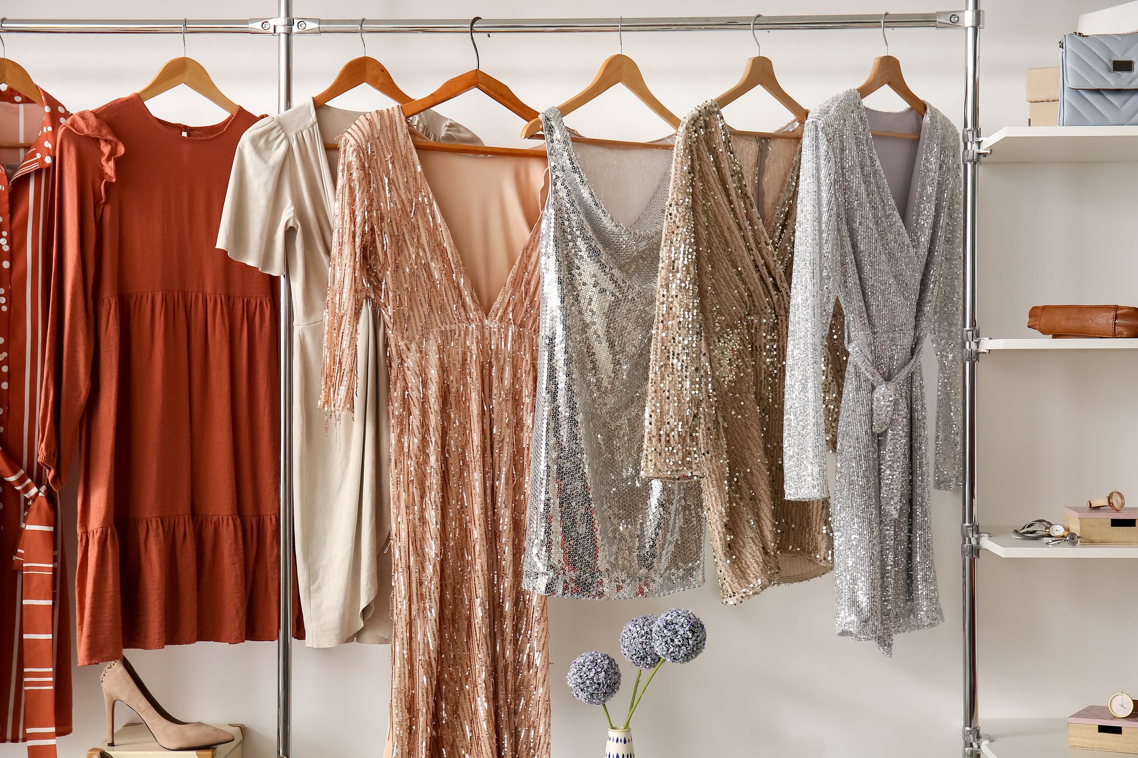 Stylish Dresses Hanging in Wardrobe in Dressing Room